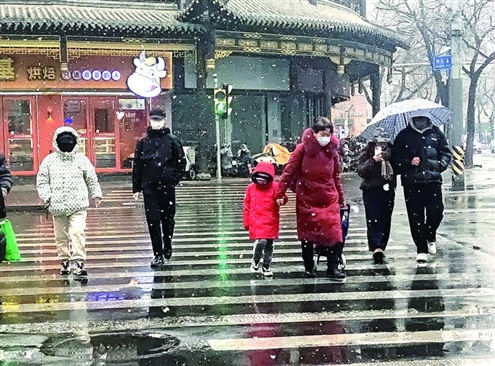 在经四路大观园附近,市民冒雪穿行马路